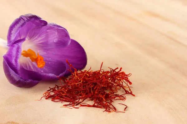 Beautiful purple crocus and saffron, on wooden background — Stock Photo, Image