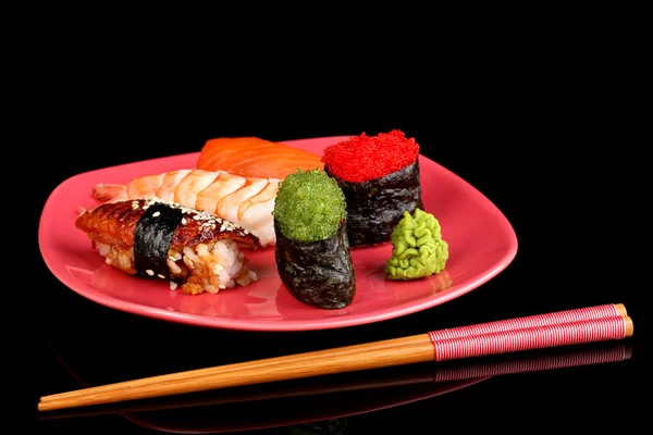 Delicious sushi served on red plate isolated on black — Stock Photo, Image