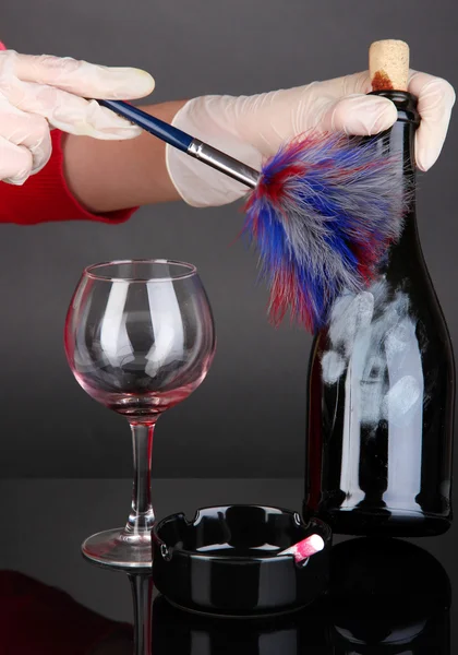 Taking fingerprints with bottle of wine isolated on black — Stock Photo, Image