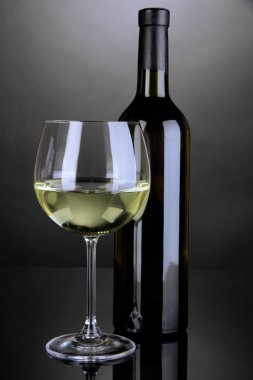 Beyaz Şarap kadehi ve gri arka plan üzerinde şarap şişe