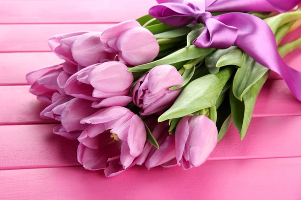 Mooi boeket van paarse tulpen op roze houten achtergrond — Stockfoto