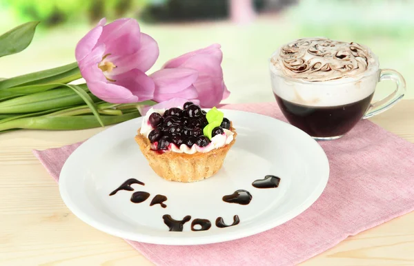 Gâteau sucré à la mûre et sauce au chocolat sur assiette, avec café, sur fond lumineux — Photo