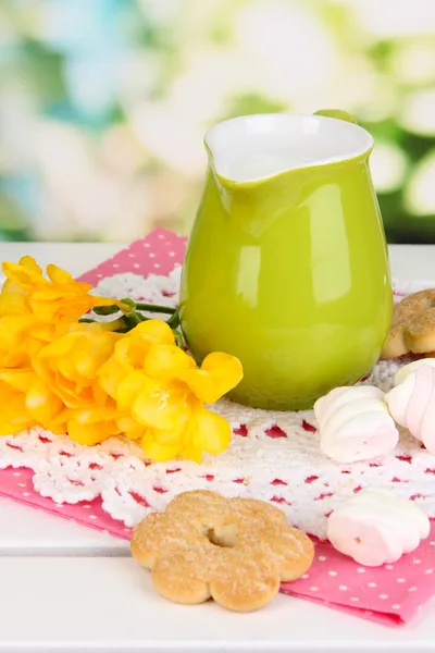 Beautiful composition of milk and cookies on wooden picnic table on natural background — Stock Photo, Image