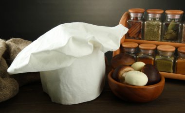 Şef'in şapkası ve kitchenwear tabloda gri arka plan üzerinde kompozisyonu