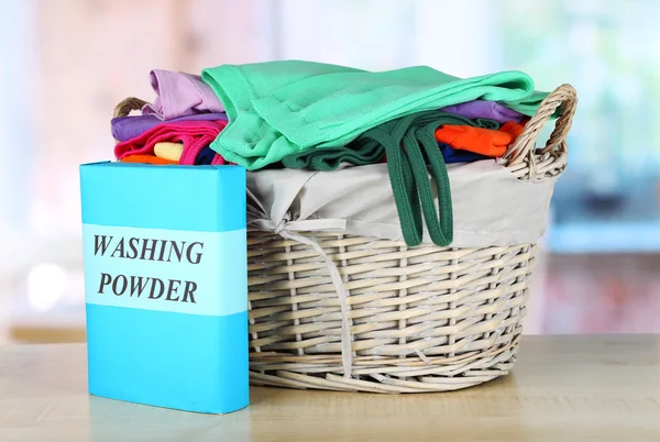 Clothes in wooden basket on table in room — Stock Photo, Image