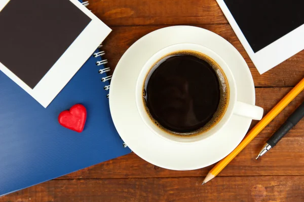 Tazza di caffè sul tavolo da lavoro ricoperta da cornici fotografiche da vicino — Foto Stock