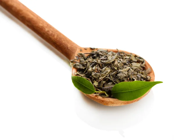 Té seco con hojas verdes en cuchara de madera, aislado sobre blanco —  Fotos de Stock