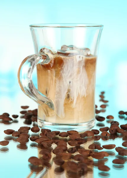 Koude koffie met ijs in glas op blauwe achtergrond — Stockfoto