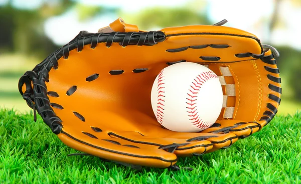 Baseball glove and ball on grass in park — Stock Photo, Image