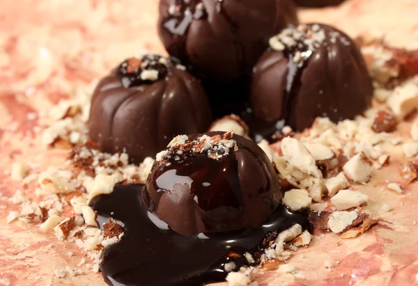Cukierki czekoladowe z orzechami, na kolor tła — Zdjęcie stockowe