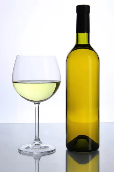 Copa de vino blanco y botella de vino aislado en blanco — Foto de Stock