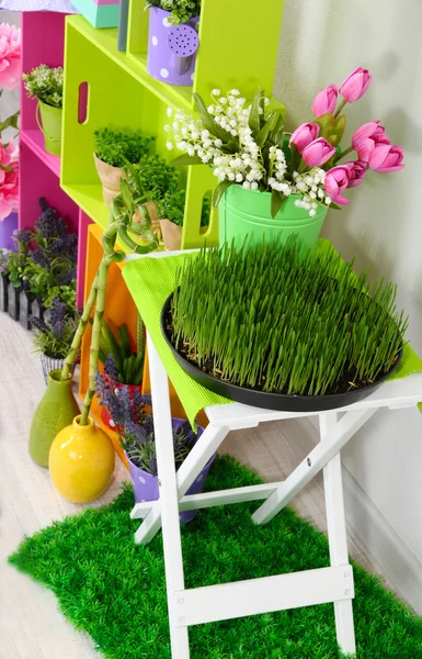 Scaffali colorati e tavolo con elementi decorativi e fiori — Foto Stock