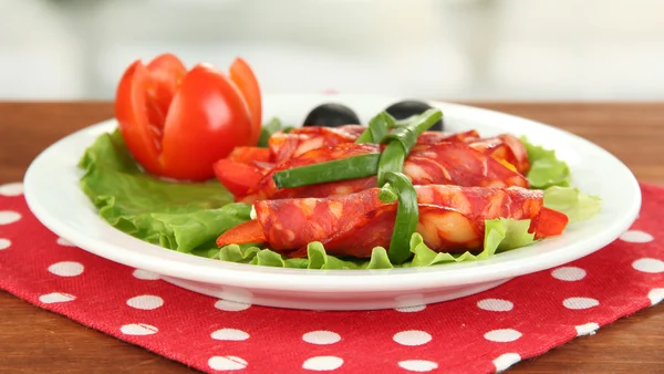 Rollos de salami sobre plato blanco sobre fondo brillante — Foto de Stock