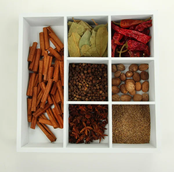 Sortimento de especiarias de aroma em caixa de madeira branca isolada em branco — Fotografia de Stock