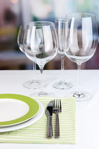 Table setting with glasses for different drinks on table on room background — Stock Photo, Image