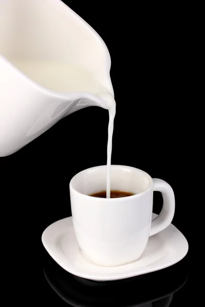 Delicate cream poured into cup of coffee isolated on black — Stock Photo, Image