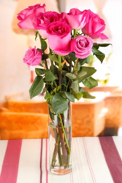 Schöne rosa Rosen in der Vase auf dem Tisch auf dem Hintergrund des Zimmers — Stockfoto