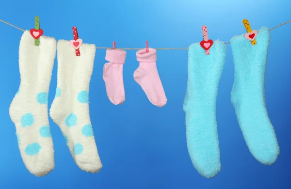 Calcetines coloridos colgando en el tendedero, sobre fondo de color —  Fotos de Stock