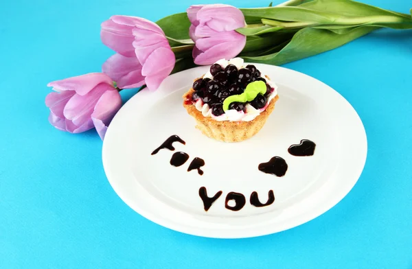 Sweet cake with blackberry and chocolate sauce on plate, on color background — Stock Photo, Image