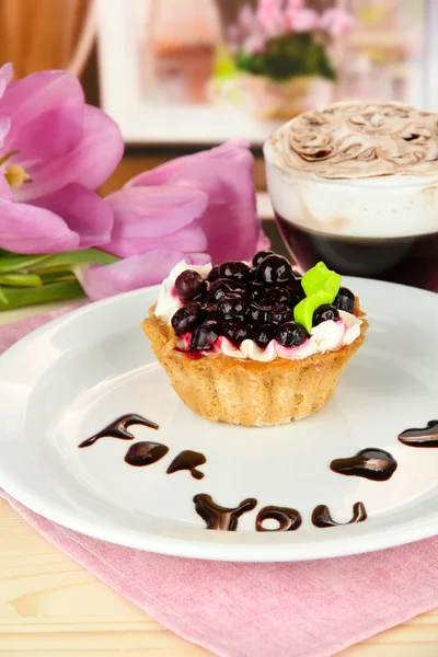 Süßer Kuchen mit Brombeer- und Schokoladensoße auf Teller, mit Kaffee, auf hellem Hintergrund — Stockfoto