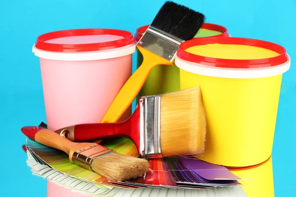 Set for painting: paint pots, brushes, palette of colors on blue background — Stock Photo, Image