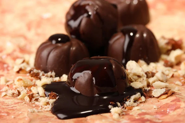 色の背景上のナッツとチョコレート菓子 — ストック写真