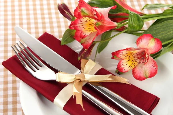 Mesa de comedor festiva con flores sobre fondo a cuadros —  Fotos de Stock