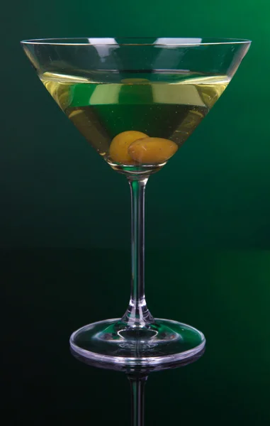 Martini-Glas mit Oliven auf dunkelgrünem Hintergrund — Stockfoto