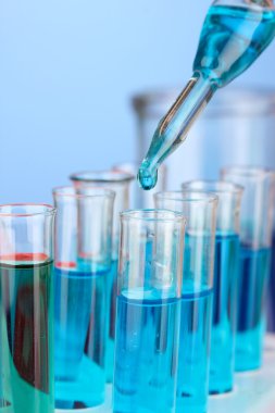Laboratuvar pipet renkli sıvı cam test tüpleri üzerinde damla ile yakın çekim