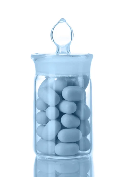 Transparent bottle with pills in grey light isolated on white — Stock Photo, Image