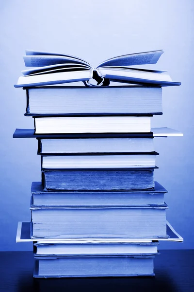 Stack of interesting books and magazines on wooden table on green background — Stock Photo, Image