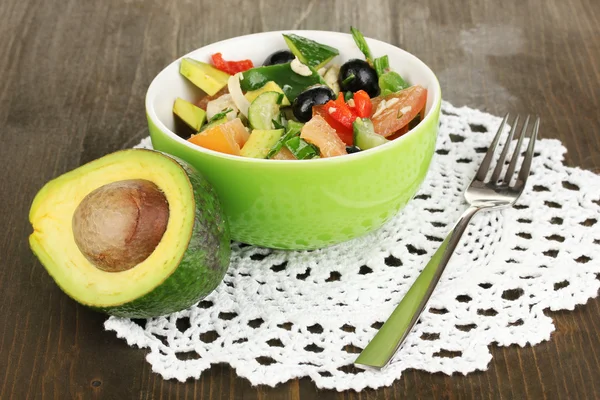 Tasty avocado salad in bowl on wooden table close-up — Stock Photo, Image