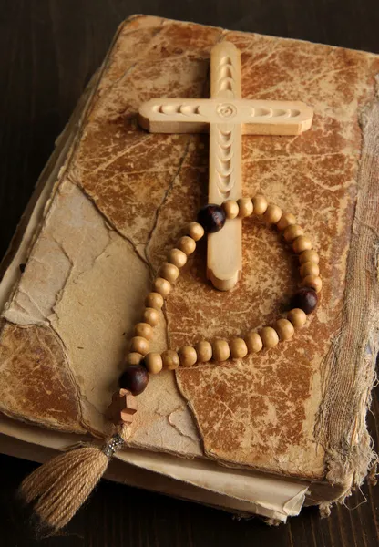 Bible, rosary and cross on wooden table close-up — Stock Photo, Image