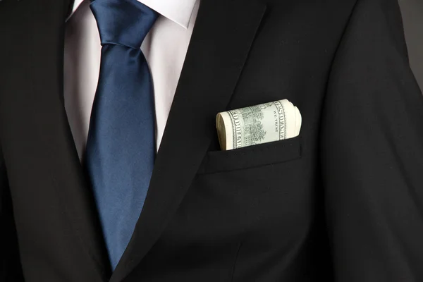 Money in pocket of businessman on black background — Stock Photo, Image