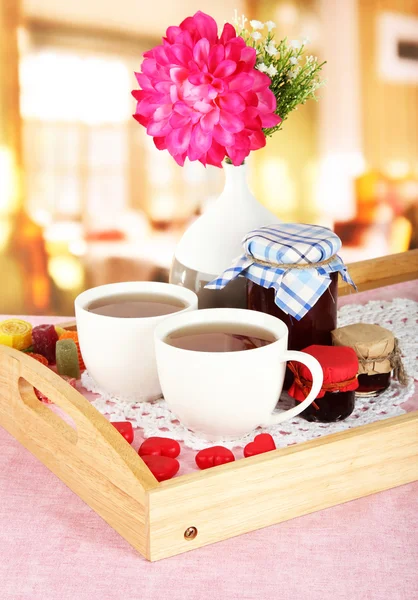 Xícaras de chá com flor e geléia na bandeja de madeira na mesa no café — Fotografia de Stock