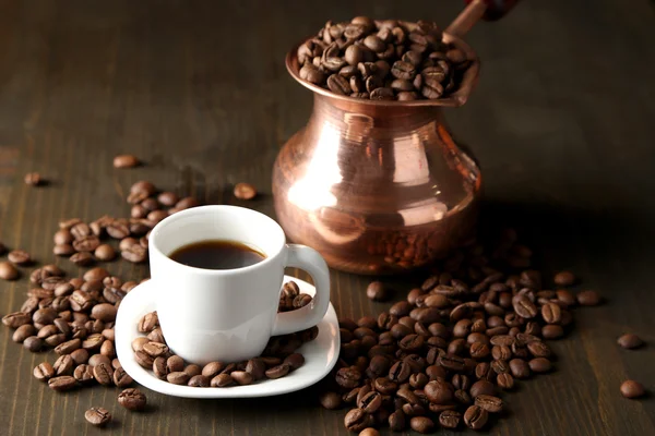 Šálek kávy a hrnec na dřevěné pozadí — Stock fotografie