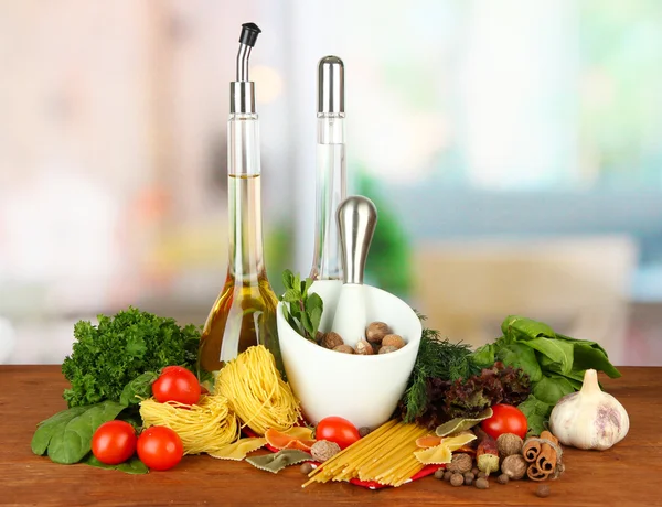 Composition of mortar, pasta and green herbals, on bright background — Stock Photo, Image