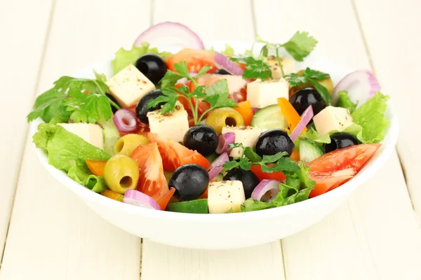 Salade fraîche dans une assiette sur une table en bois — Photo