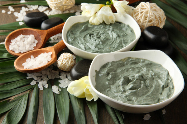 Composition with cosmetic clay for spa treatments, on palm leaf background