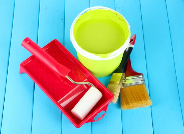 Boyama için ayarla: boya pot, fırçalar, mavi ahşap masa üzerinde rulo — Stok fotoğraf