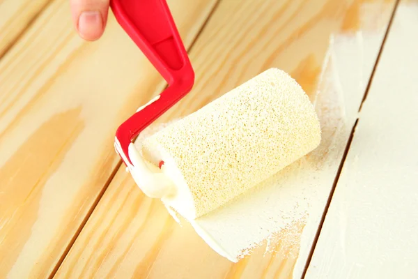 Paint roller brush with white paint, on wooden background — Stock Photo, Image