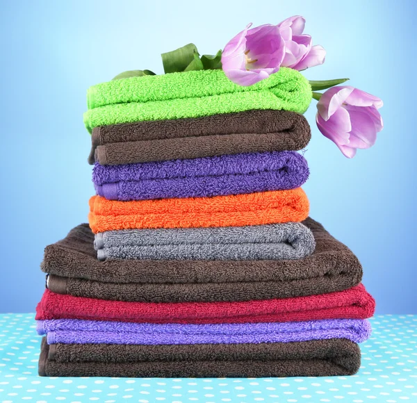 Pile of colorful towels, on blue background — Stock Photo, Image