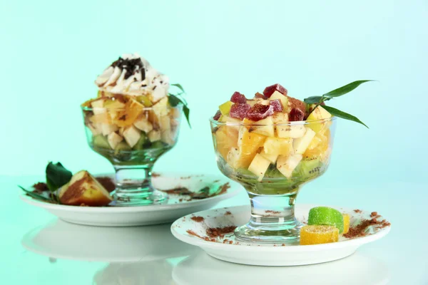 Ensalada de frutas en un plato de helado sobre un fondo azul —  Fotos de Stock