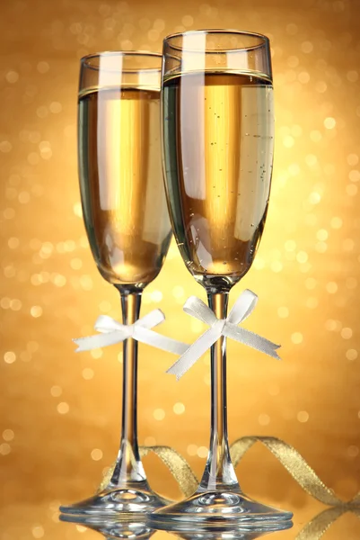 Två glas champagne på ljus bakgrund med ljus — Stockfoto