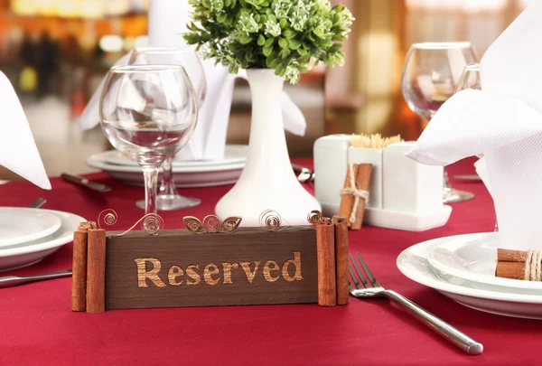 Sinal reservado na mesa do restaurante com pratos e copos vazios — Fotografia de Stock
