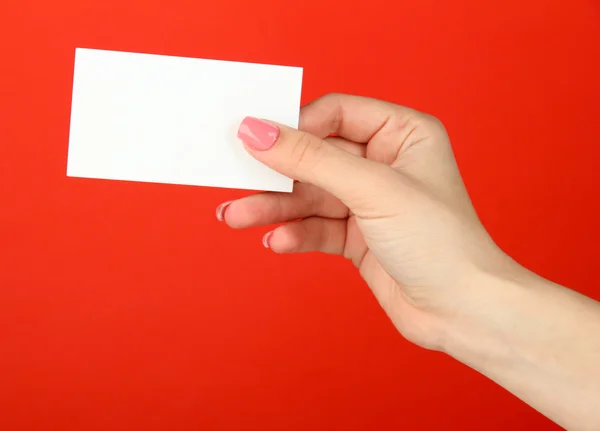 色の背景上のビジネス カードを持っている女性手 — ストック写真