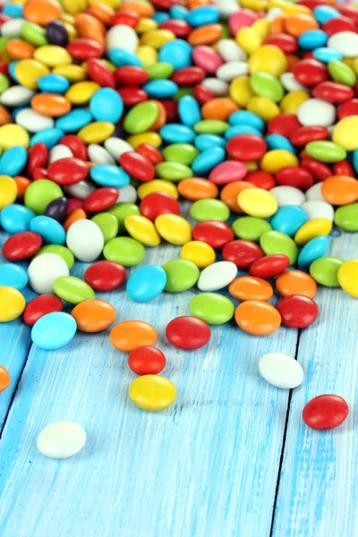Bunte Bonbons auf blauem Holzhintergrund — Stockfoto