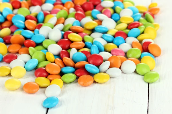 Beyaz ahşap arka plan üzerinde renkli şekerler — Stok fotoğraf