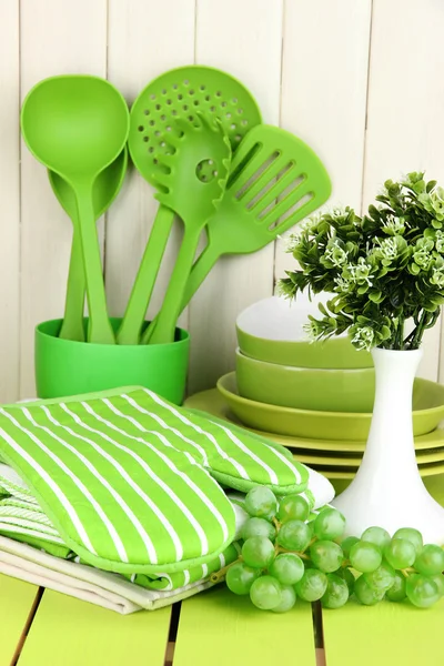 Kitchen settings: utensil, potholders, towels and else on wooden table — Stock Photo, Image