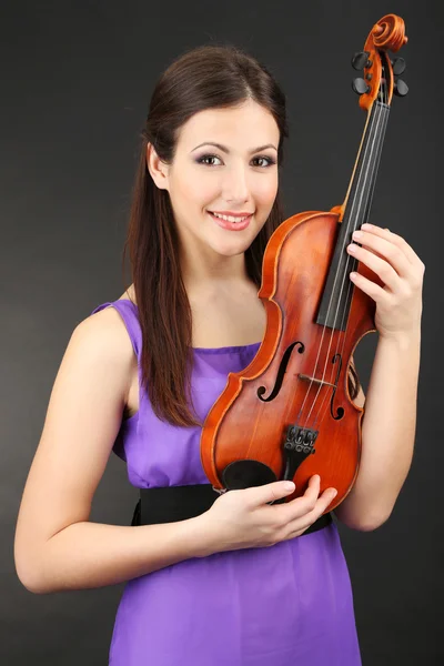 Beautiful young girl with violin on grey background — Stock Photo, Image